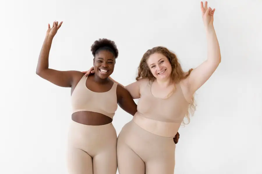 Confident happy women posing while wearing a body shaper